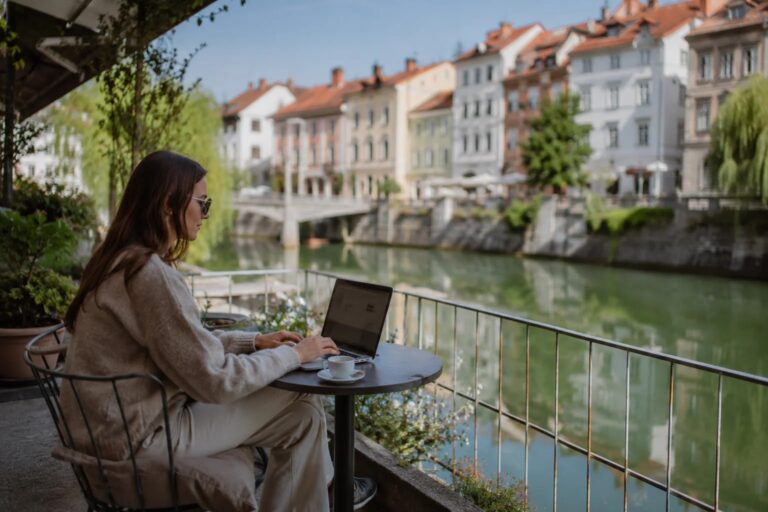 Laptop on a riverside café terrace along the Ljubljanica in Ljubljana