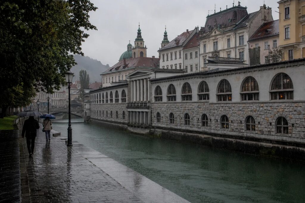 Rain over the Ljubljanica and the market colonnade in Ljubljana