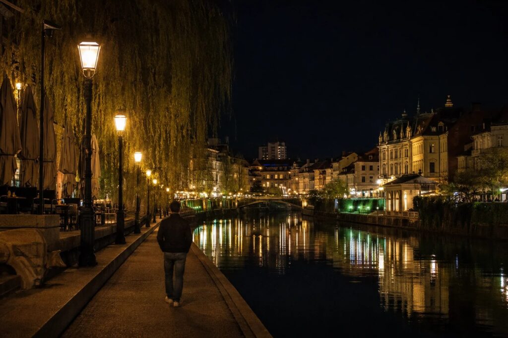 Calm illuminated riverside on a night walk in Ljubljana