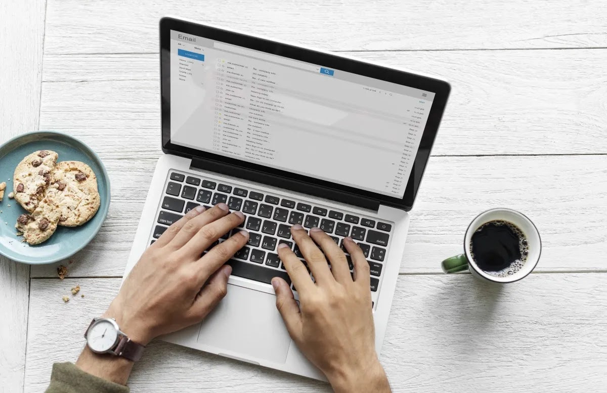 Entrepreneur writing a business plan on a laptop with coffee